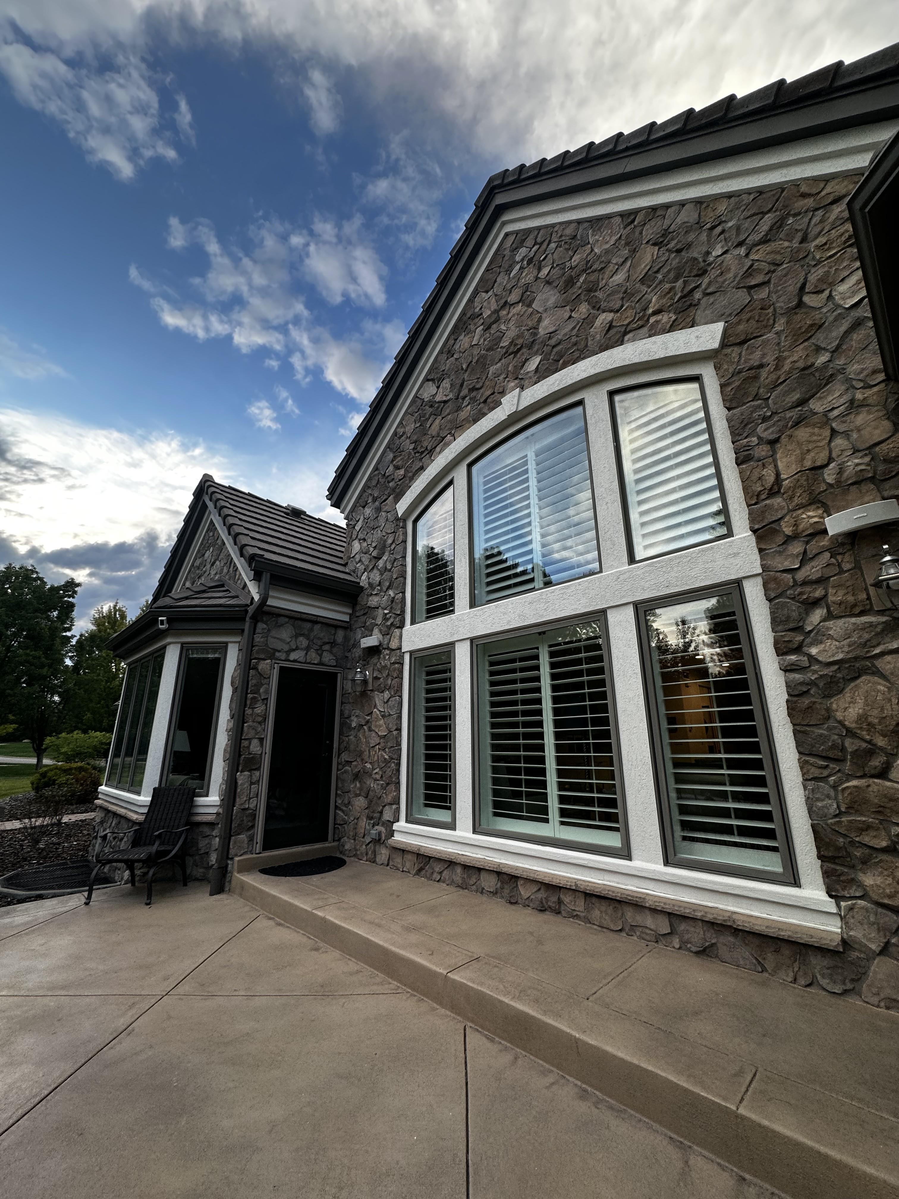 Curved exterior window bay beside a stone patio